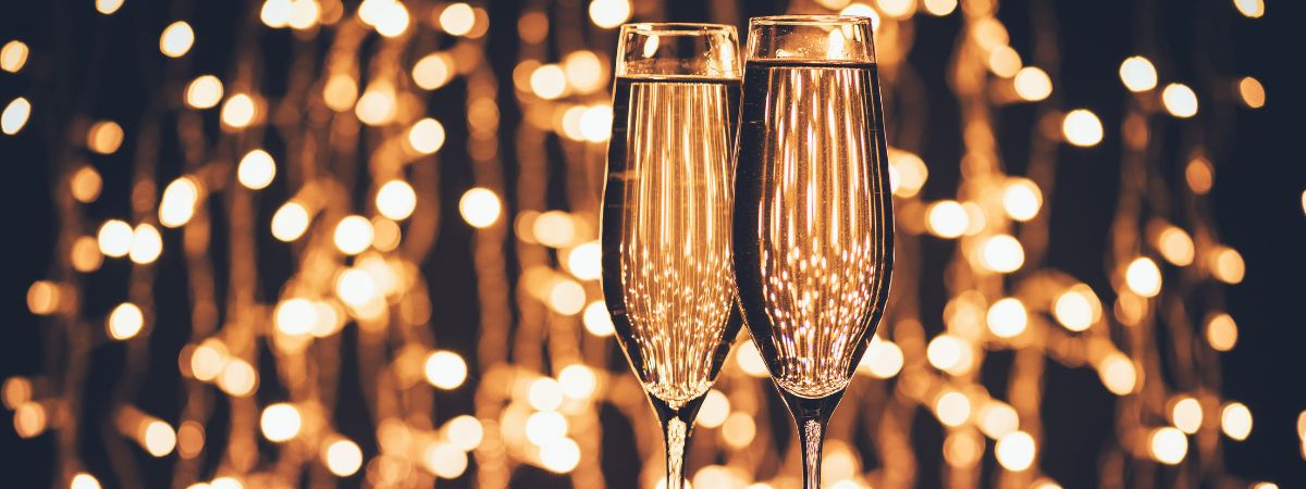 Two champagne glasses in front of lights